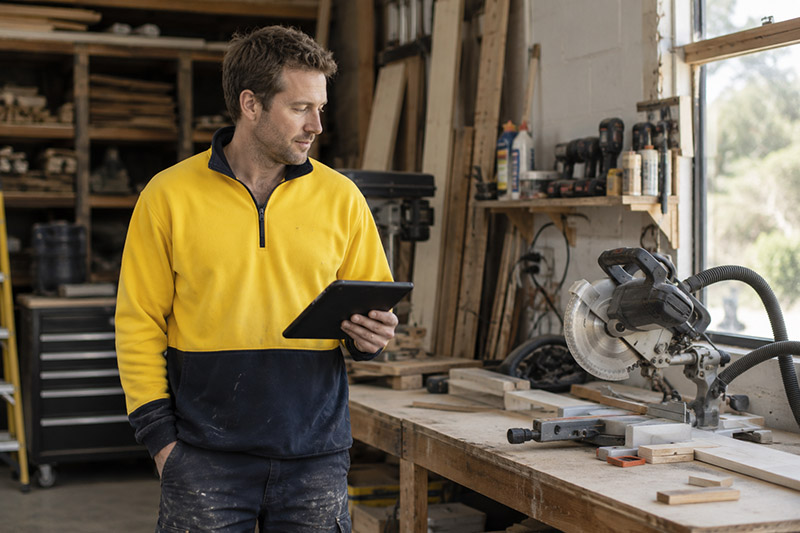 Carpenter in a workshop with tablet