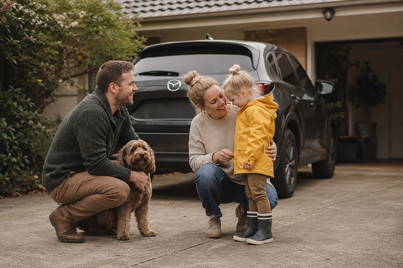 Family and dog in suburban driveway
