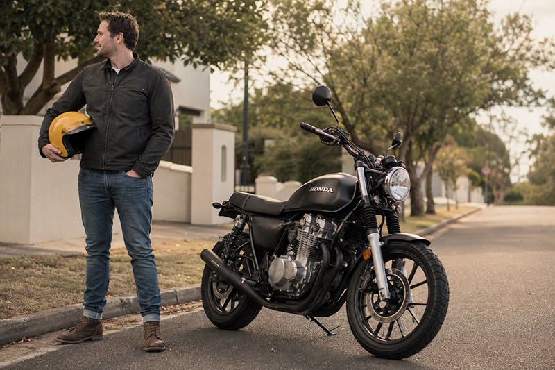 Man with helmet beside motorcycle on street