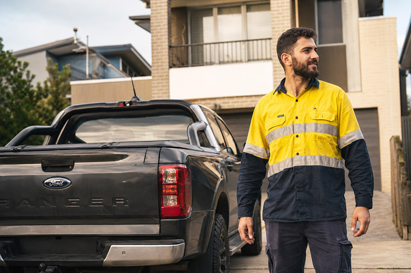 Workman with pickup truck by house